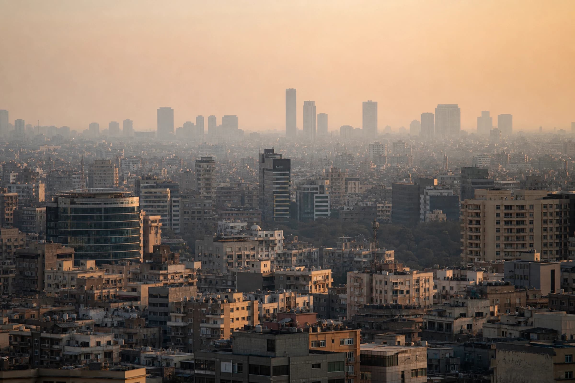 Cairo rooftops and towers stacked in late-light haze.